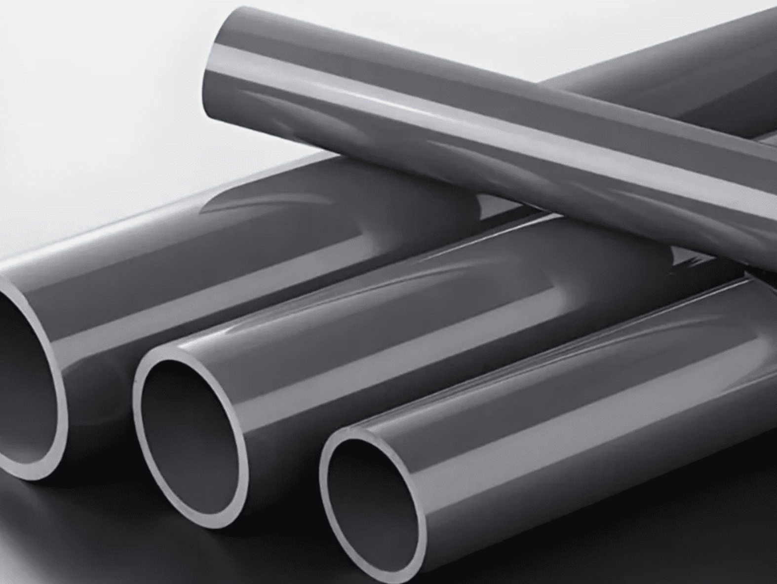 ABS vs PVC pipes comparison showing multiple gray pipes stacked together.