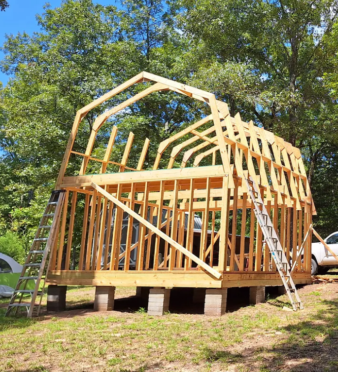 Off-grid water system pipes and fittings installation in a wooden framework structure.