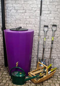 Midi Metro 185 Litre Water Butt - Purple Slim Cylindrical Tank next to gardening tools and a watering can.