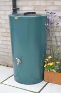 Green City Just Water 210 Litre Water Butt - Green beside flowering plants in a garden setting.