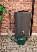 City Just Water 210L Millstone Effect Water Butt - Slimline beside shovel and watering can against brick background.