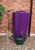 City Just Water 210L Water Butt - Purple Cylindrical Design next to watering can and shovel