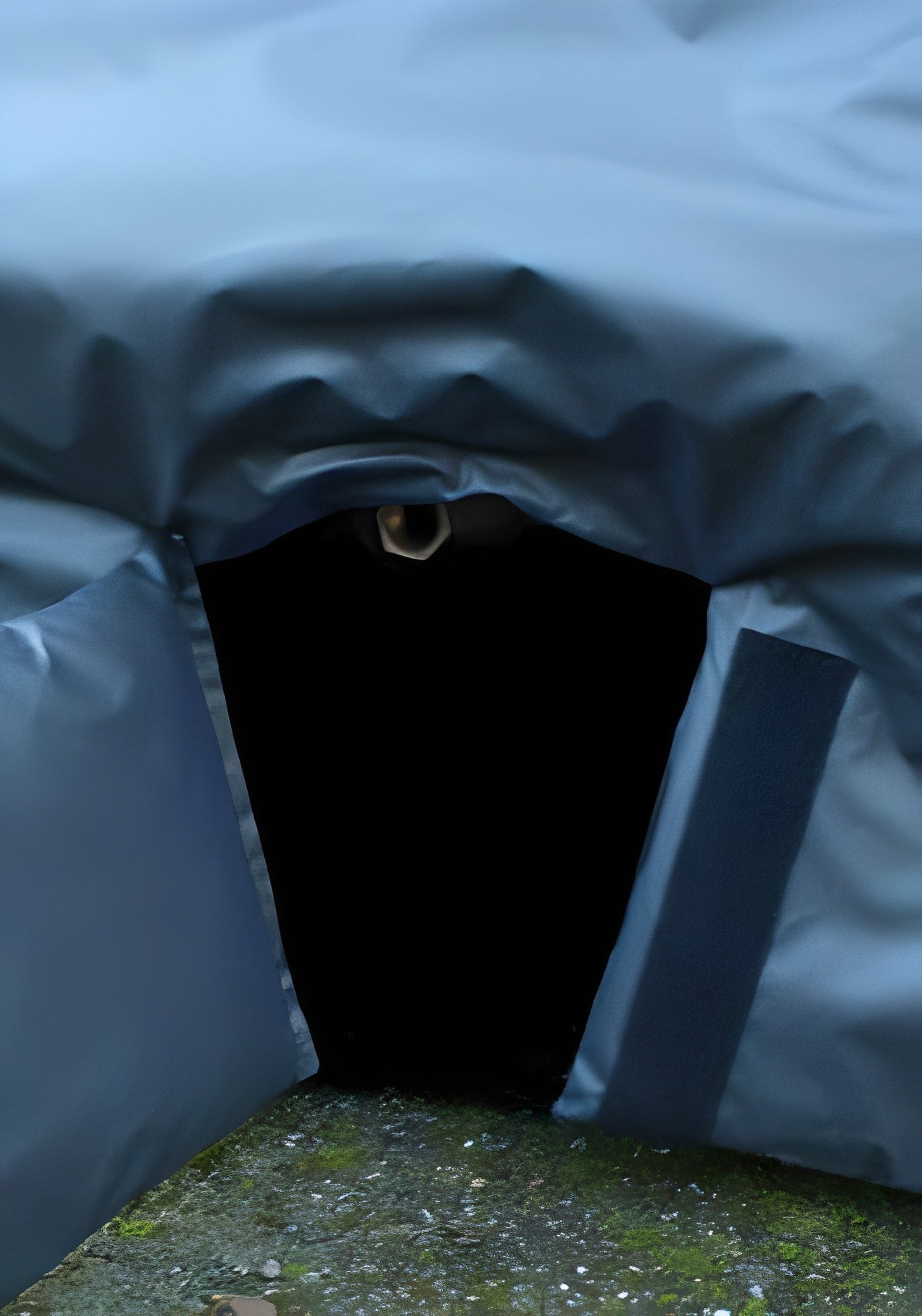 Door opening of a dark, insulated pet shelter with a protective cover.