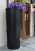 Black Big City Water Butt Planter - 380L Capacity with vibrant flowers, stylish outdoor water collection.