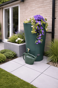 Green City 180L Water Butt Planter - Decorative Rainwater Tank with flowers and watering can in a garden setting.