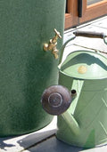 Big City Water Butt Planter - Green Marble 380L beside a vintage green watering can on a patio.
