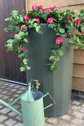 Green Marble Midi Metropolitan Water Butt Planter - 165L with flowers and green watering can.