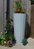 Grey Metropolitan 2-in-1 Water Butt Planter - 255L Grey featuring vibrant plants against a wooden fence.