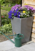 Millstone Cambridge 90L Water Butt Planter - Stone Effect with colorful flowers and watering can.