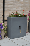Millstone Oasis 375 Litre Water Butt Planter - Millstone Effect with flowers on a patio
