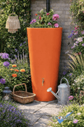 Orange Big City Water Butt Planter - 380L Orange surrounded by flowers and garden accessories.