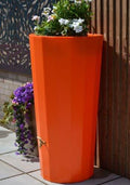 Orange Metropolitan Water Butt Planter - 255L Decorative Tank with flowers on top in a modern garden setting.