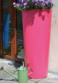 Pink Big City Water Butt Planter - 380L Capacity with flowers and a green watering can.