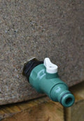 Green tap attachment on a rainwater tank for easy water dispensing.