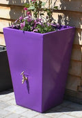 Purple Cambridge 90L Water Butt Planter - Decorative Tank with flowers growing, rainwater collection spout visible.
