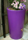 Purple City 180L Water Butt Planter - Decorative Rainwater Tank with flowers on top in a garden setting.