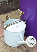 Metropolitan 255L Water Butt Planter - Purple Decorative Storage with a watering can next to it.