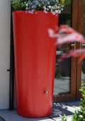 Red Big City Water Butt Planter - 380L Capacity Red with flowers, enhancing outdoor aesthetics.