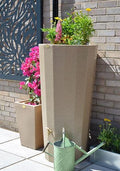Metropolitan 255L Water Butt Planter - Sandstone Effect with flowering plants and watering can.