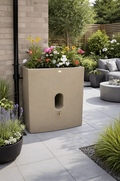 Sandstone Oasis 375 Litre Water Butt Planter - Sandstone Effect with flowers in a modern garden setting.