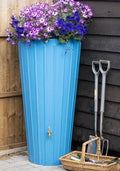 Cosmo 200L Water Butt Planter - Sky Blue Decorative Tank with flowers in a modern garden setting.