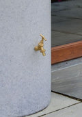 Close-up of the faucet on a White Marble Big City Water Butt Planter - 380L Capacity.